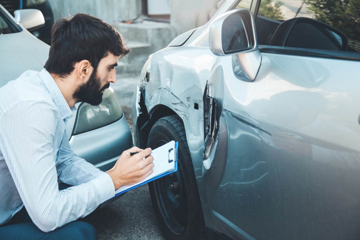 Ajustador anota los daños de un auto después de un choque